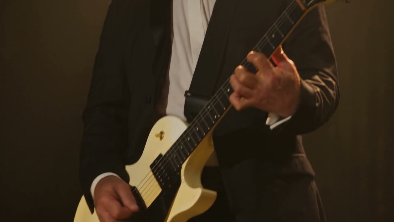Amplified guitarist performing under stage lights